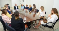 #PraTodosVerem: Vista lateral da mesa de reunião. Uma das integrantes do Comitê fala enquanto ou...
