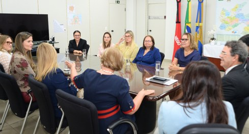 #PraTodosVerem: Um homem e uma mulher  conversam sorrindo durante a reunião, sentados lado a lad...