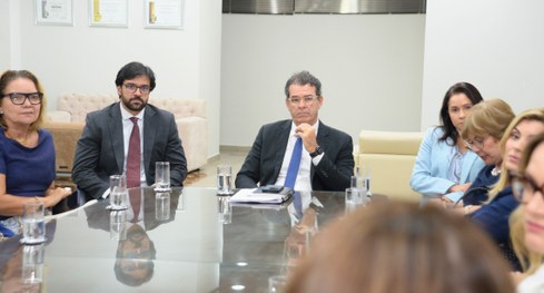 #PraTodosVerem: Um homem e uma mulher  conversam sorrindo durante a reunião, sentados lado a lad...
