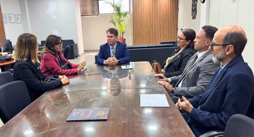 #PraTodosVerem: Na fotografia aparece um grupo de pessoas reunidas em torno de uma mesa numa sal...