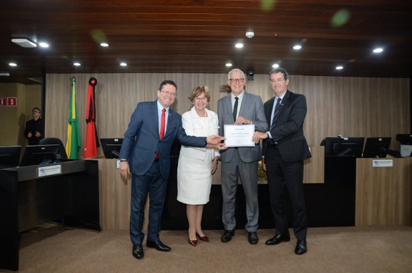 #PraTodosVerem: Na fotografia, quatro pessoas posam sorrindo segurando um certificado. Ao fundo,...