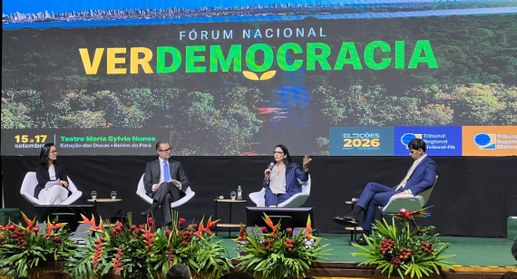 #PraTodosVerem: Na fotografia, o palco de um evento, com quatro pessoas sentadas em poltronas. N...