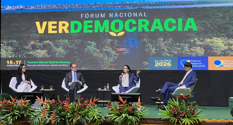 #PraTodosVerem: Na fotografia, o palco de um evento, com quatro pessoas sentadas em poltronas. N...
