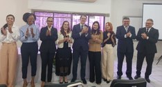 #PraTodosVerem: Na fotografia aparecem várias pessoas, em pé, posando; em segundo plano aparece ...