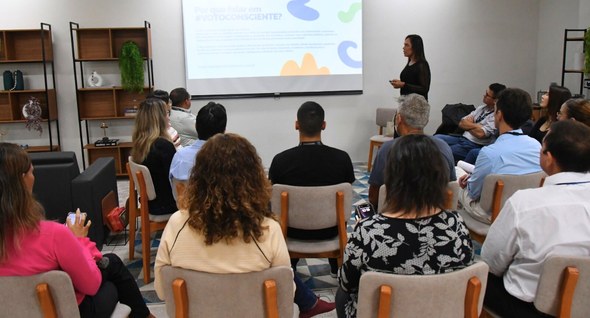 roda_de_conversa_3 Foto 2: #PraTodosVerem: Na fotografia aparece um grupo de pessoas sentadas de frente para uma te...