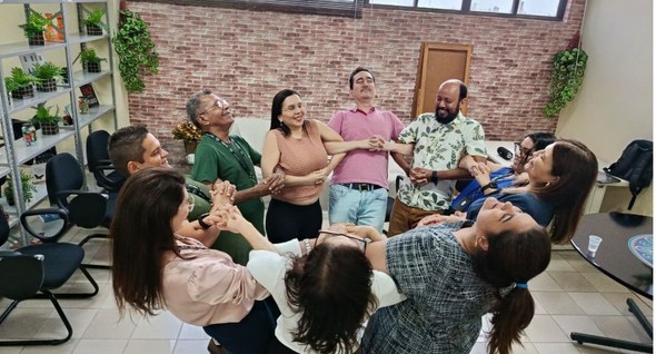 #PraTodosVerem: Na fotografia interna aparece um grupo em um círculo, se apoiando em cada um por...