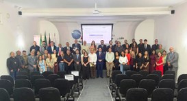 #PraTodosVerem: Na fotografia aparece um grupo de pessoas posando para fotos em pé num auditório 
