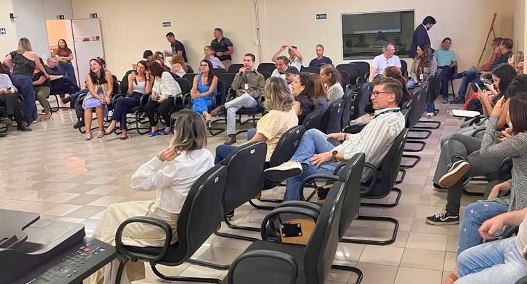 #PraTodosVerem: Na fotografia aparece um grupo de pessoas, com variadas idades e etnias, sentada...