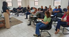 #PraTodosVerem: Na fotografia aparecem pessoas sentadas em cadeiras, enquanto duas mulheres, em ...