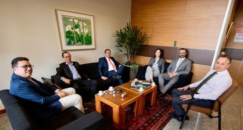 #PraTodosVerem: Na fotografia aparecem seis pessoas sentadas, em uma sala de reunião. O espaço é...