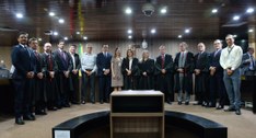 Os juízes Membros da Corte Eleitoral posam, de pé, com alguns integrantes da comissão que minuto...