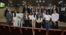 #ParaTodosVerem: Alunos do Unipê fotografados com a Corte Eleitoral, todos de pé na sala de sess...