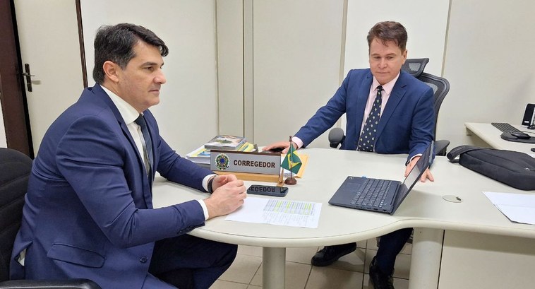 TRE-PB cria Gabinete Virtual para cumprir metas e indicadores do CNJ #PraTodosVerem: Na imagem aparecem dois homens em reunião em torno de uma mesa com um notebook