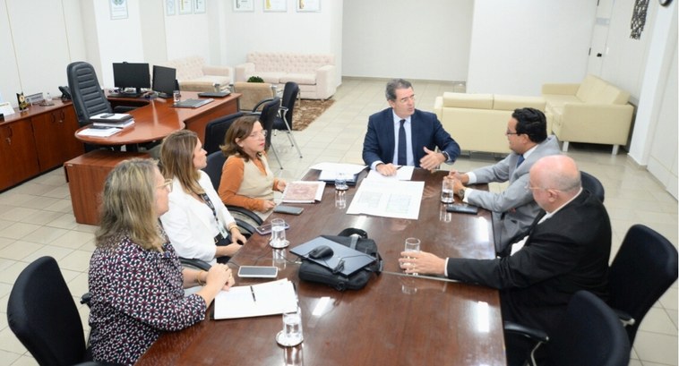 #PraTodosVerem: Ao redor de uma grande mesa de reuniões de vidro, 6 pessoas participam de uma re...