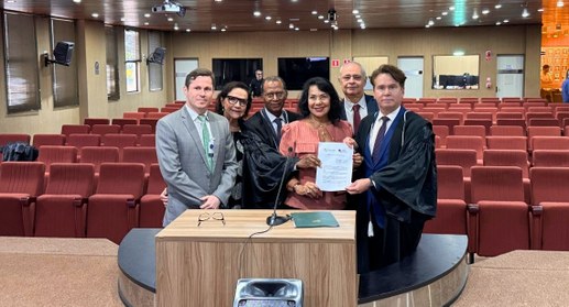 #PraTodosVerem: Na fotografia aparecem um grupo de pessoas posando com o termo de Cooperação ent...
