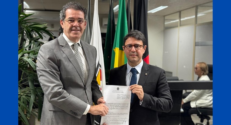 TRE-PB e MPPB assinam termo para viabilizar usina fotovoltaica #PraTodosVerem: Na fotografia, dois homens em pé em uma sala com bandeiras ao fundo. Eles estão ...