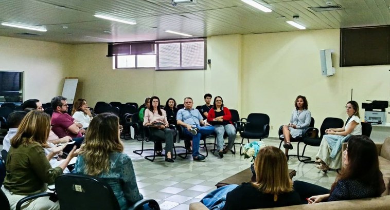 #PraTodosVerem: Na fotografia aparecem pessoas em uma roda de conversa, olhando para a mediadora...