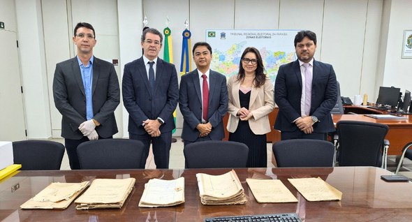 #PraTodosVerem: Na fotografia, aparecem cinco pessoas posando para foto tendo a frente uma mesa ...