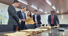 #PraTodosVerem: Na fotografia aparece cinco pessoas analisando documentos históricos dispostos e...