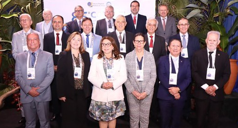 TRE-PB encontro de presidentes Painel retangular com dezessete pessoas de pé, sendo três delas mulheres, posando para fotografia.