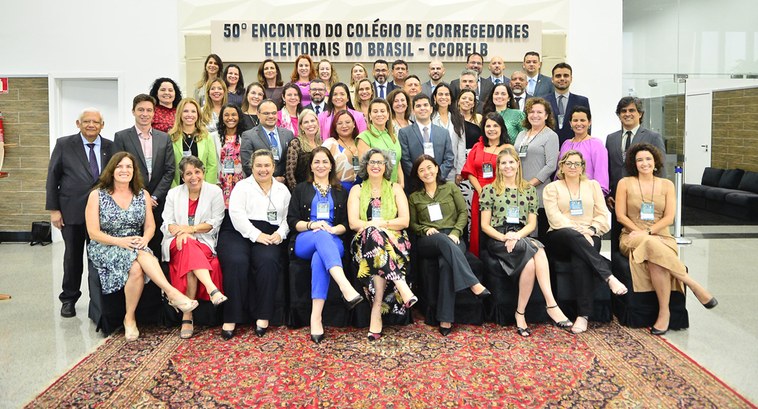 Pessoas de pé e sentadas posando para fotografia no encontro de secretários e secretárias das Co...