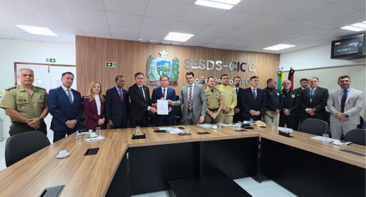 #PraTodosVerem: Na fotografia, aparece um grupo de pessoas em pé em uma sala, com três delas ao ...