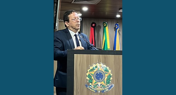 #PraTodosVerem: Na fotografia aparece um homem em traje formal gesticulando em um púlpito com um...