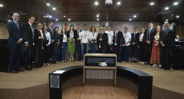 TRE-PB maratona-liods Painel retangular com pessoas de pé, posando para fotografia, na sala de sessões do TRE da Paraíba.