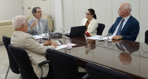 #PraTodosVerem: Quatro pessoas, sendo três homens e uma mulher, sentadas à mesa de reunião na sa...