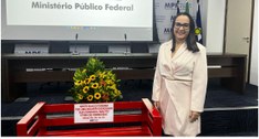 #PraTodosVerem: Na fotografia aparece uma mulher ao lado de um banco vermelho e por trás um arra...