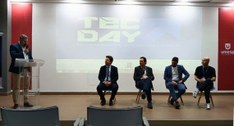 #PraTodosVerem: Na fotografia aparece o palco de um auditório, onde quatro homens estão sentados...