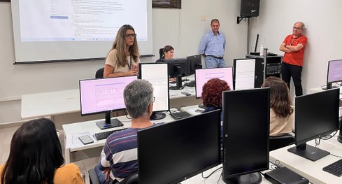 #PraTodosVerem: Na fotografia, um grupo de pessoas está reunido em uma sala de treinamento, sorr...