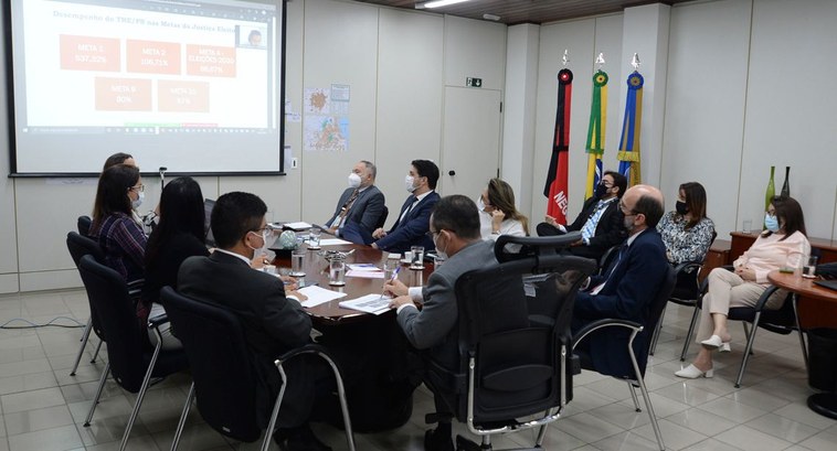 TRE-PB promove reunião de Gestão Participativa de Metas para 2023 #PraTodosVerem: Na fotografia aparecem os participantes da reunião, sentados em volta de uma mes...