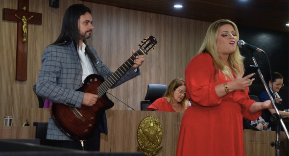 #PraTodosVerem: Na fotografia aparece um homem segurando uma guitarra e uma mulher cantando em u...