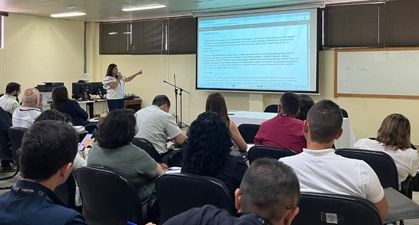 Foto 5: #PraTodosVerem: Na fotografia aparece uma mulher em pé, usando uma camisa branca, de fre...