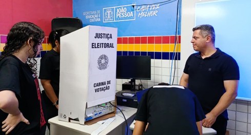 #PraTodosVerem: Na fotografia aparece uma criança com deficiência física votando na urna eletrôn...