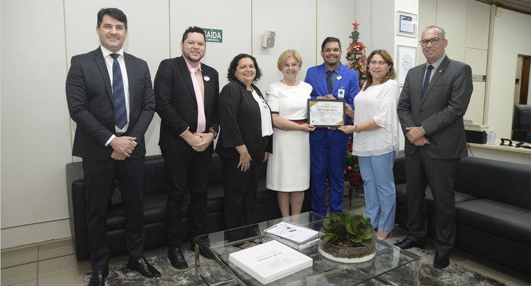 TRE-PB recebe Selo Iguais na Diversidade #ParaTodosVerem: Painel retangular com sete pessoas de pé, posando para fotografia.