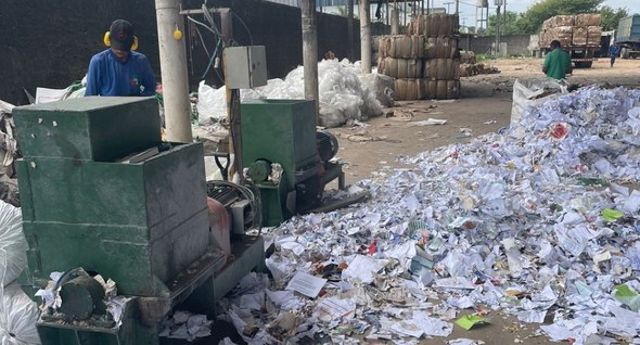 #PraTodosVerem: Na fotografia aparece o pátio de uma usina de reciclagem. Um homem com abafadore...
