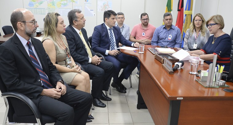 Pessoas sentadas em volta de um birô.