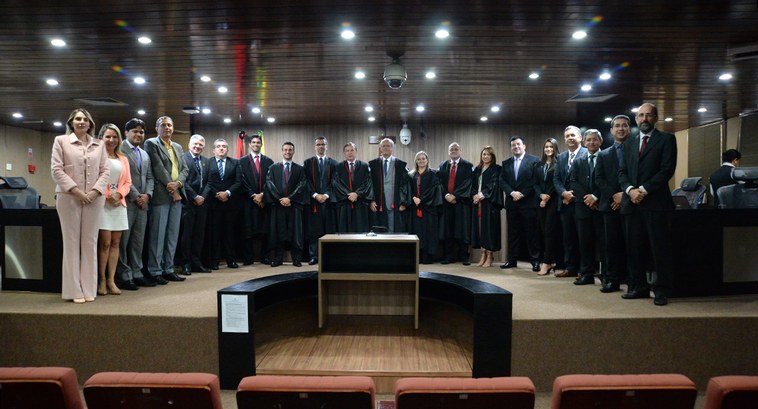 Juízes da Corte Eleitoral e servidores posam, à frente da mesa do tribunal, para fotografia de d...
