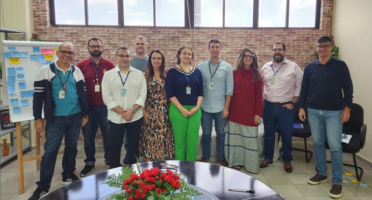 #ParaTodosVerem: Painel retangular com dez pessoas de pé, sendo três mulheres, todas posando par...