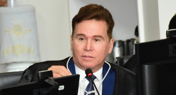 #PraTodosVerem: Na fotografia aparece um homem, em primeiro plano, vestindo toga preta e gravata...