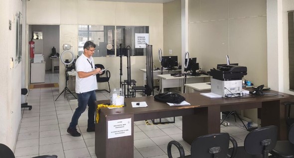PraTodosVerem: Na fotografia aparecem um homem, em pé, com uma prancheta nas mãos, em um cartóri...