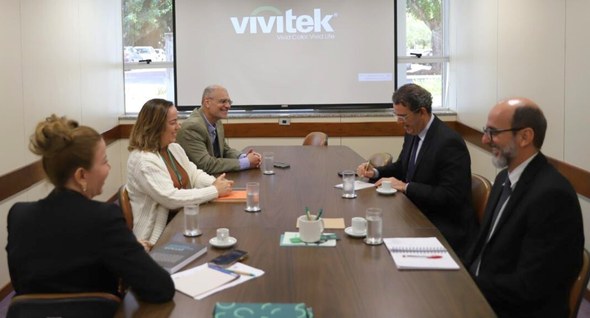 #PraTodosVerem: Na fotografia aparecem pessoas reunidas em volta de uma mea de madeira, sugerind...