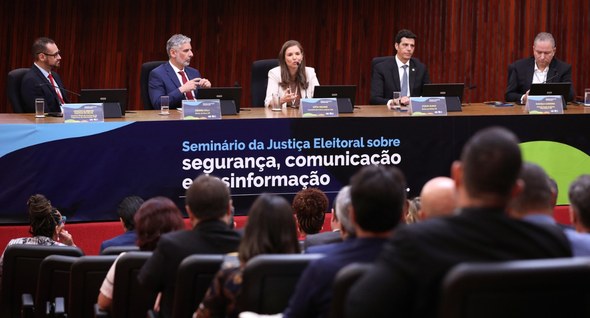 #PraTodosVerem: Na fotografia aparece uma mesa composta por cinco autoridades em um auditório, c...