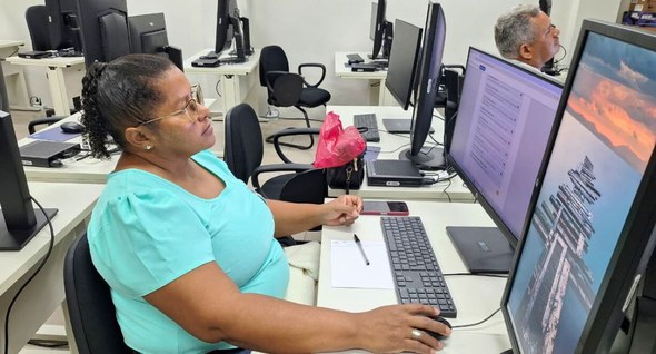 #PraTodosVerem: Na fotografia aparece uma mulher sentada numa sala de treinamento olhando para a...
