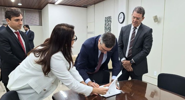 Juiz federal Bianor Bezerra toma posse como membro substituto TRE-PB #PraTodosVerem: foto de Capa: Na fotografia aparece o juiz assinando termo de posse a diretora-g...