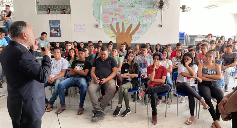 TRE-PB realiza palestra educativa para alunos da Escola Cidadã Integral João Caetano #PraTodosVerem: Alunas e alunos da ECI João Caetano, sentados em cadeiras, assistindo a palestra...